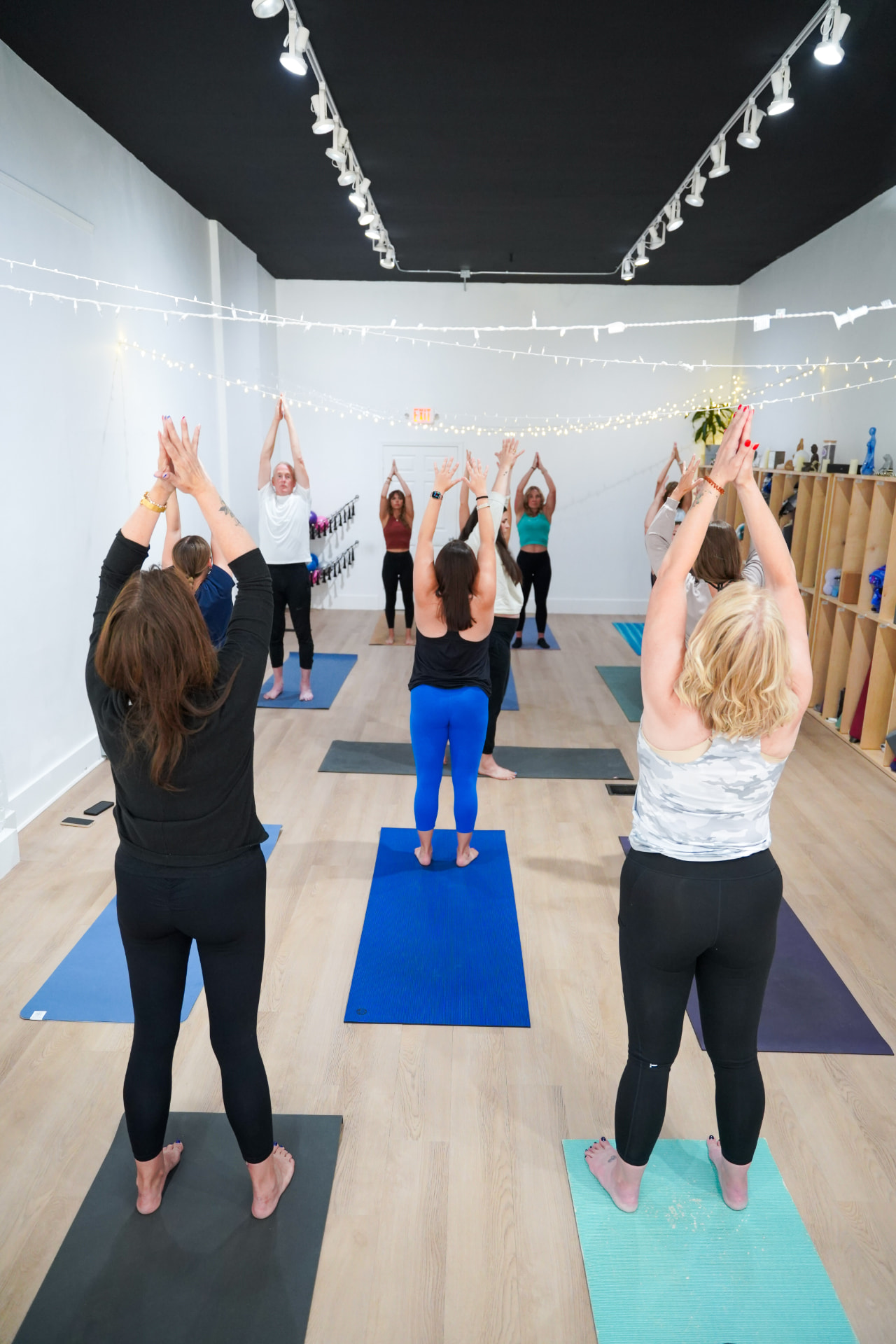 A full class of students reaching overhead together at Homegrown Yoga in Bellefontaine