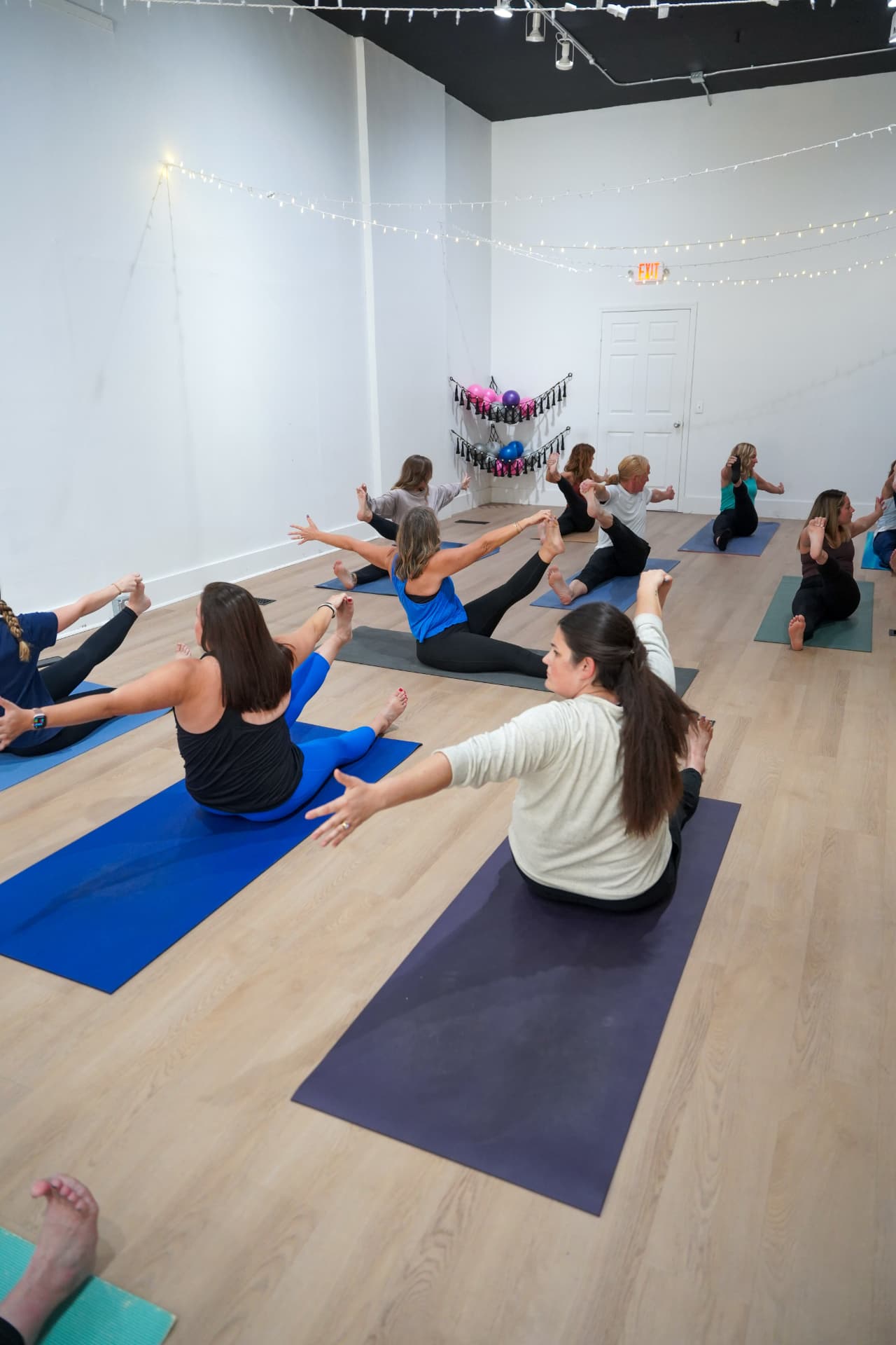 Rows of students working through boat pose during a sculpt class