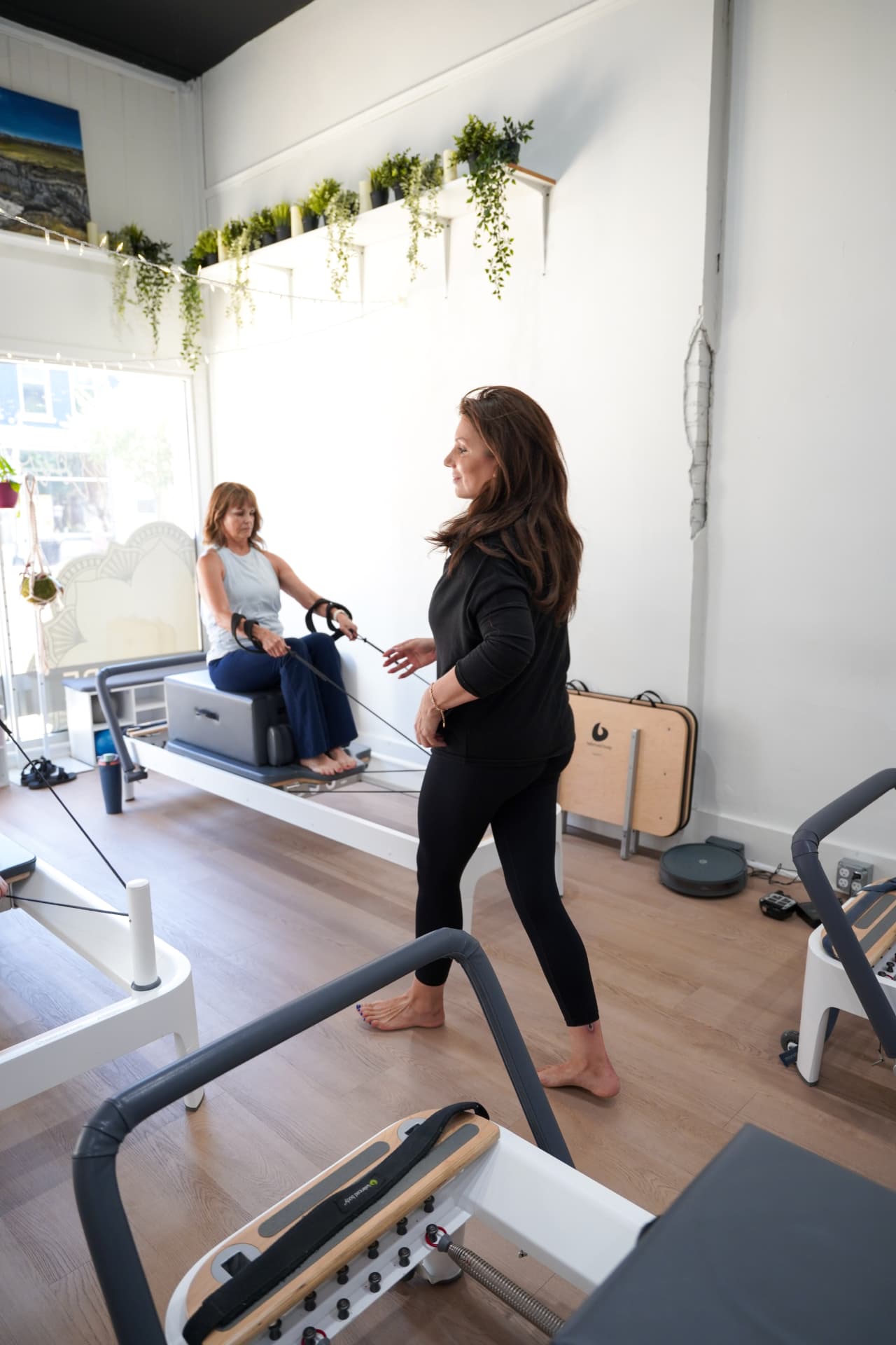 An instructor guiding a client through footwork on the reformer